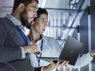 Image of a man and woman holding a laptop